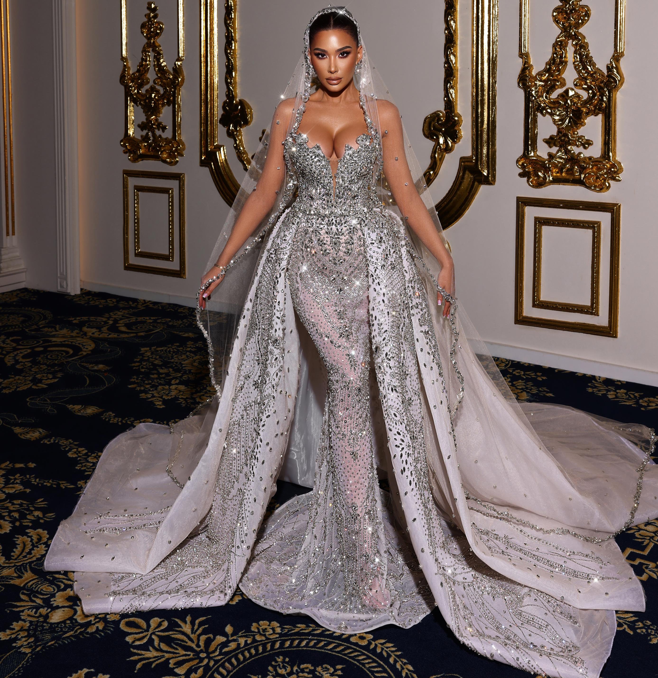 Woman in a sparkling silver wedding gown standing in an ornate room.