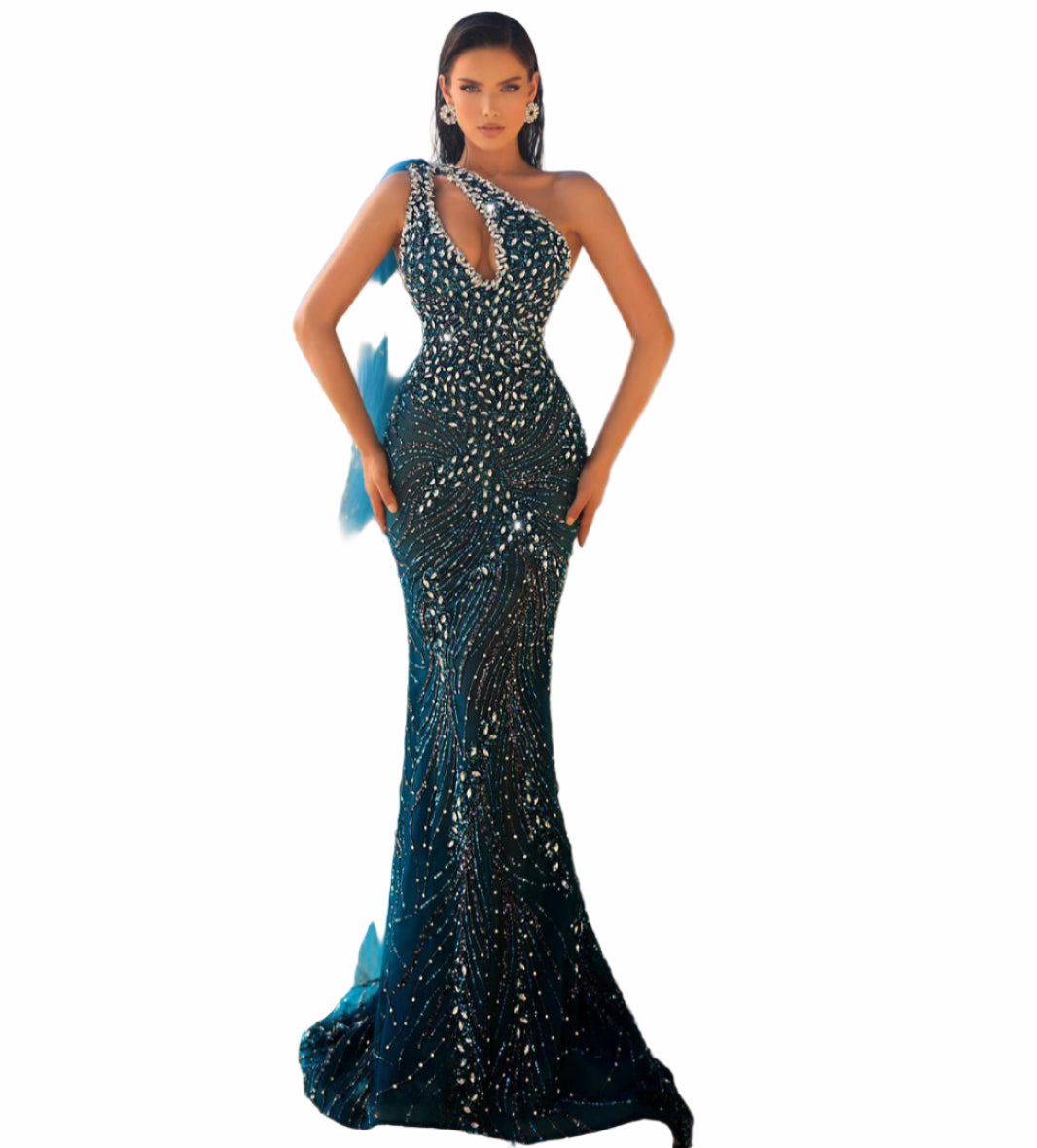 Woman in a black sequined gown with a blue train 