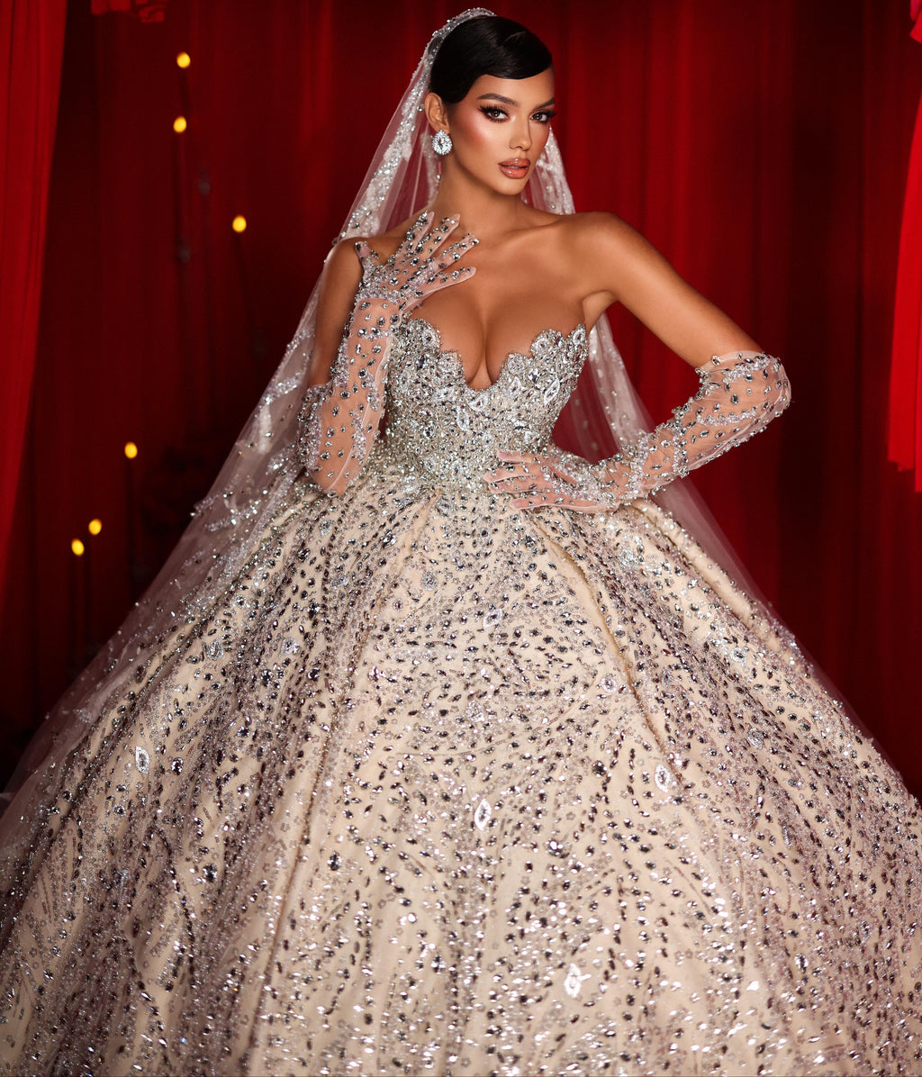 Woman in a sparkling gown with a red curtain backdrop