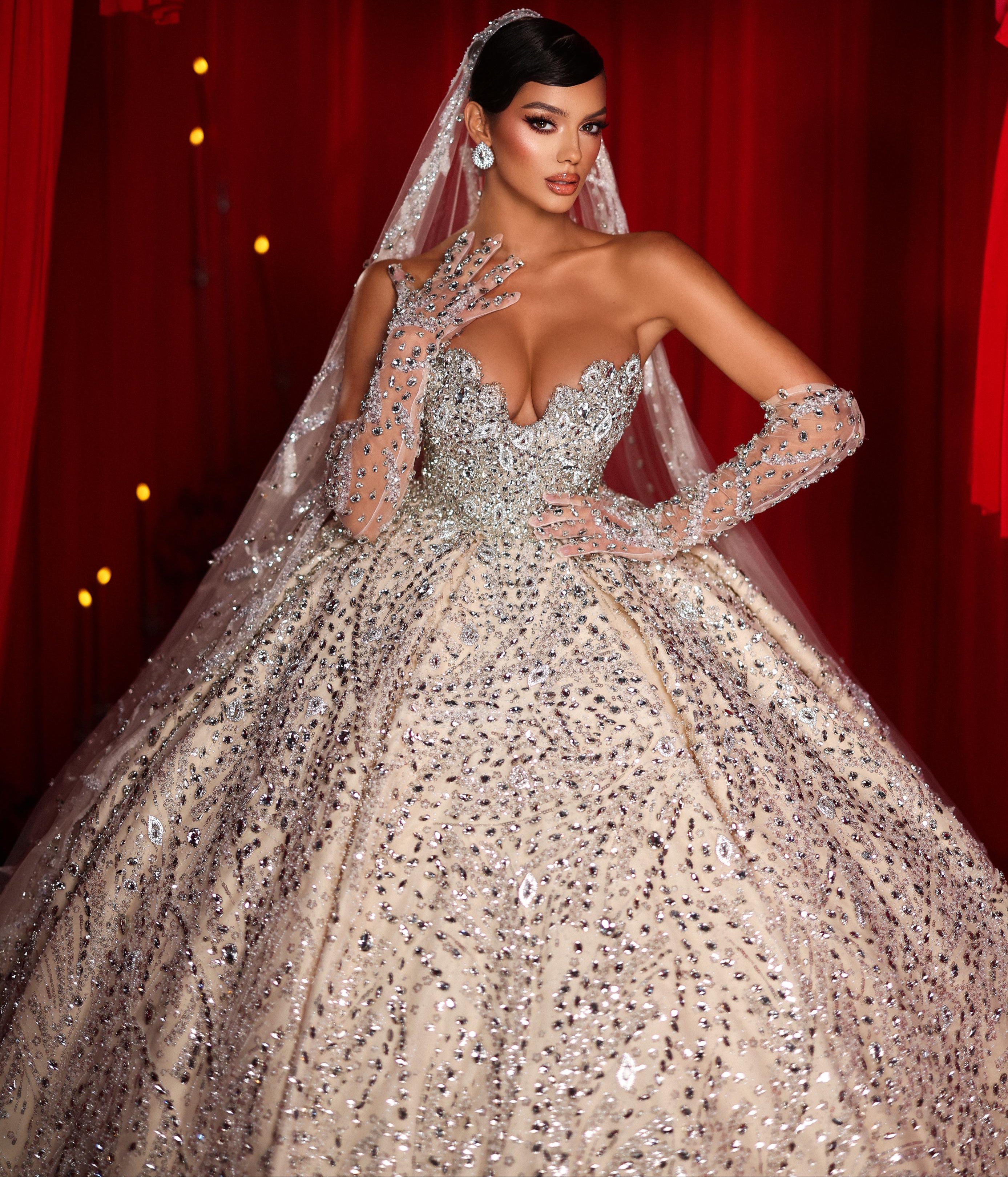 Woman in a sparkling gown with a red curtain backdrop
