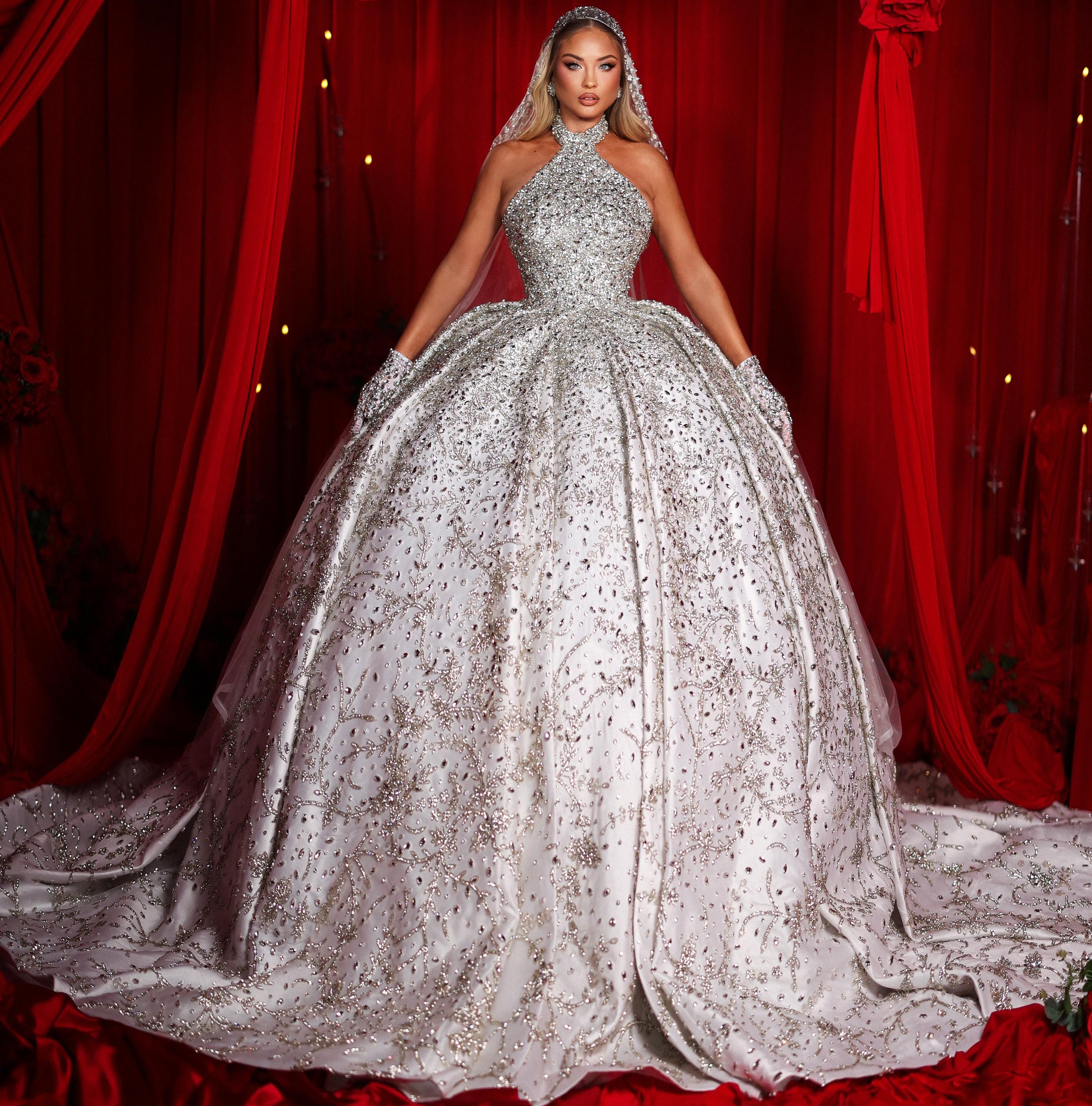 Woman in a sparkling silver ball gown against a red curtain backdrop