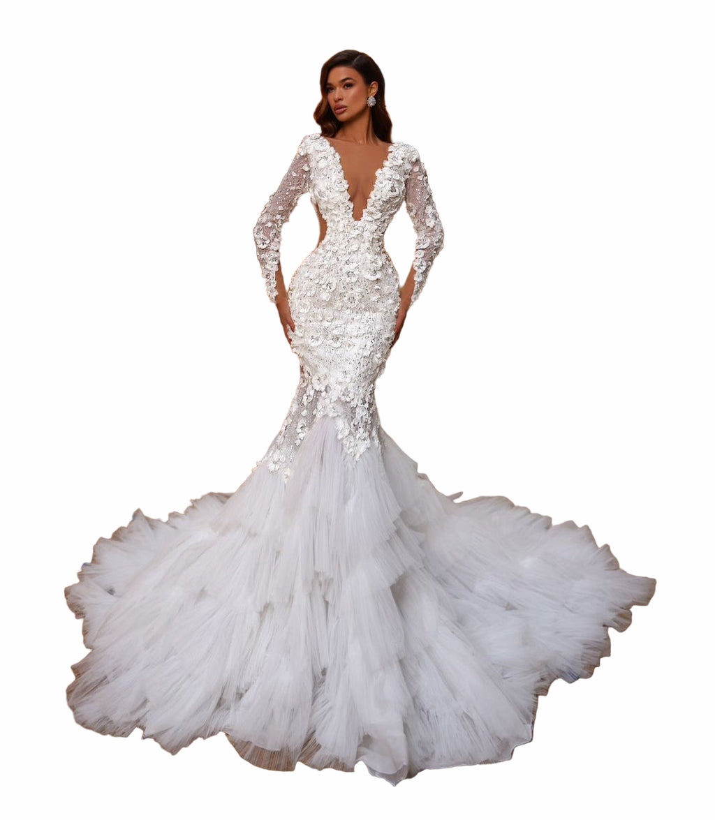 Woman in a white wedding dress standing in an elegant indoor setting with architectural details.