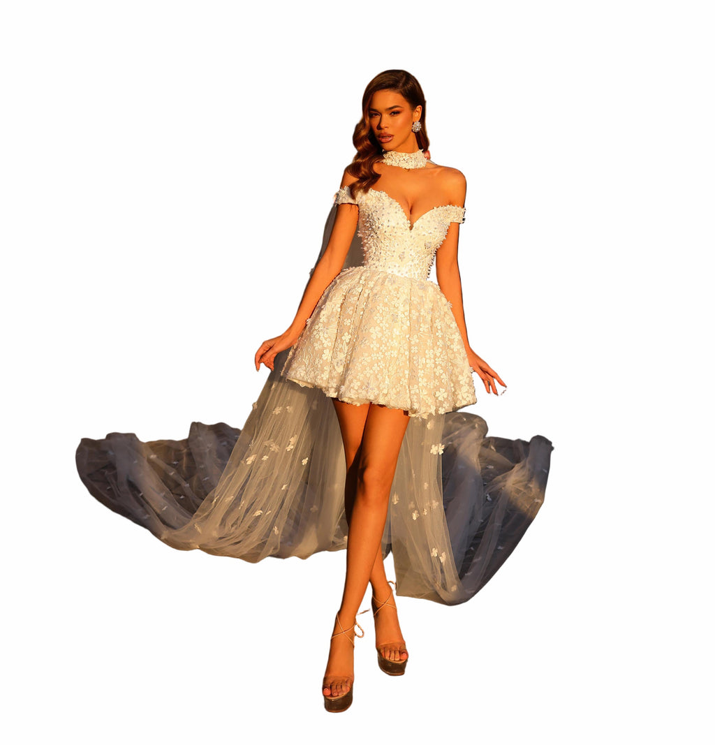 Woman in a white lace dress standing on a city street with classical architecture.