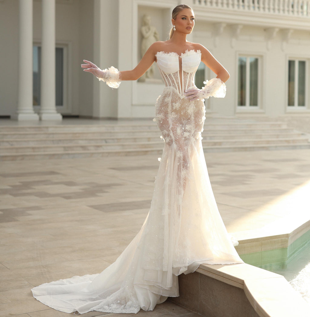 Woman in a white wedding dress standing in front of an elegant building.