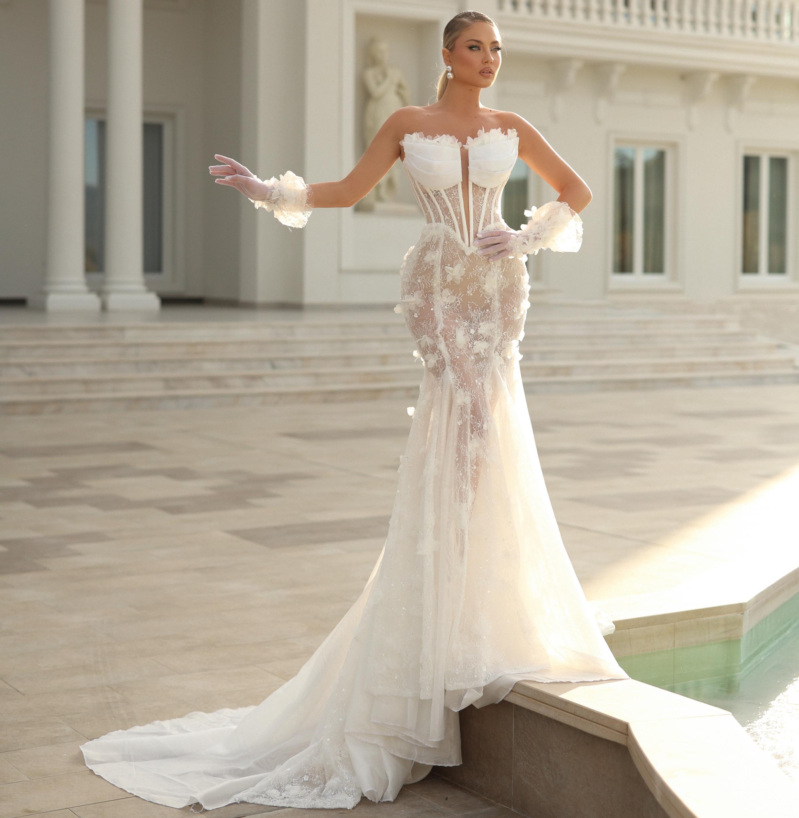 Woman in a white wedding dress standing in front of an elegant building.