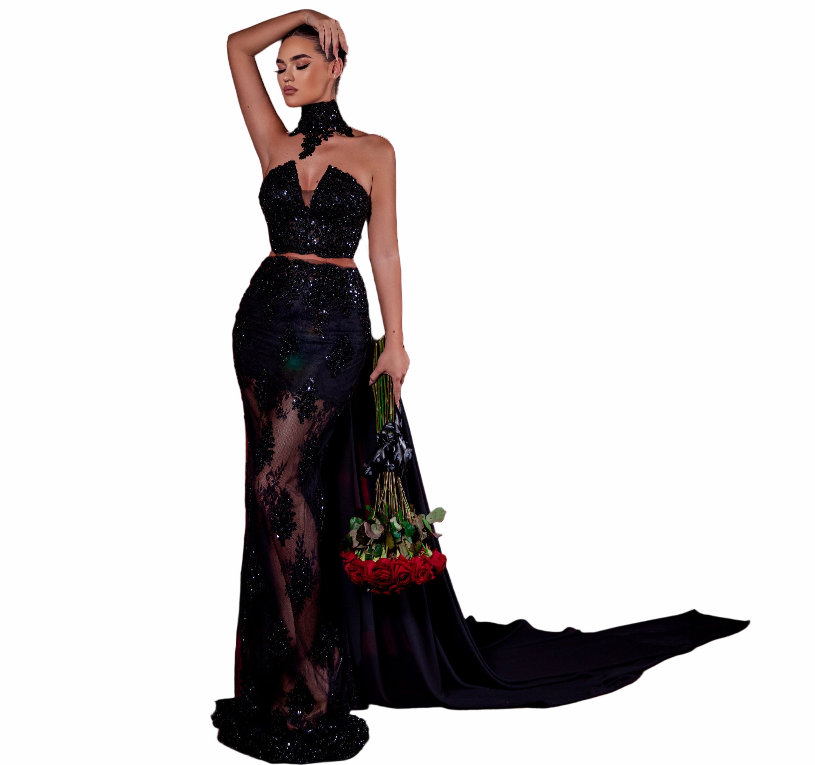 Woman in a black dress standing in an empty theater with red seats.