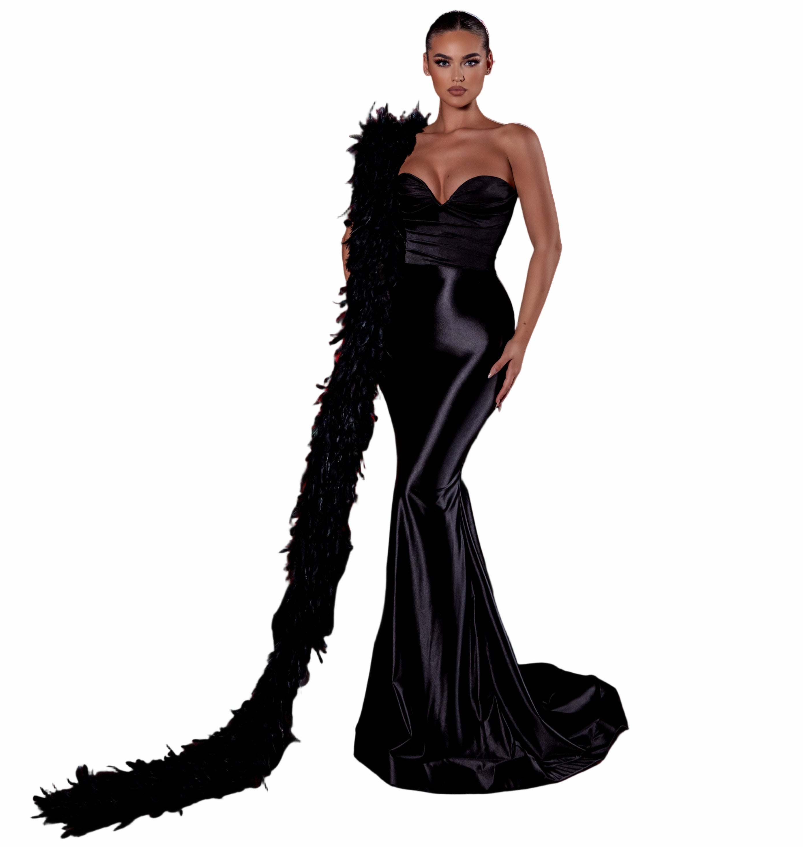 Woman in a black evening gown standing in an empty theater with red seats.