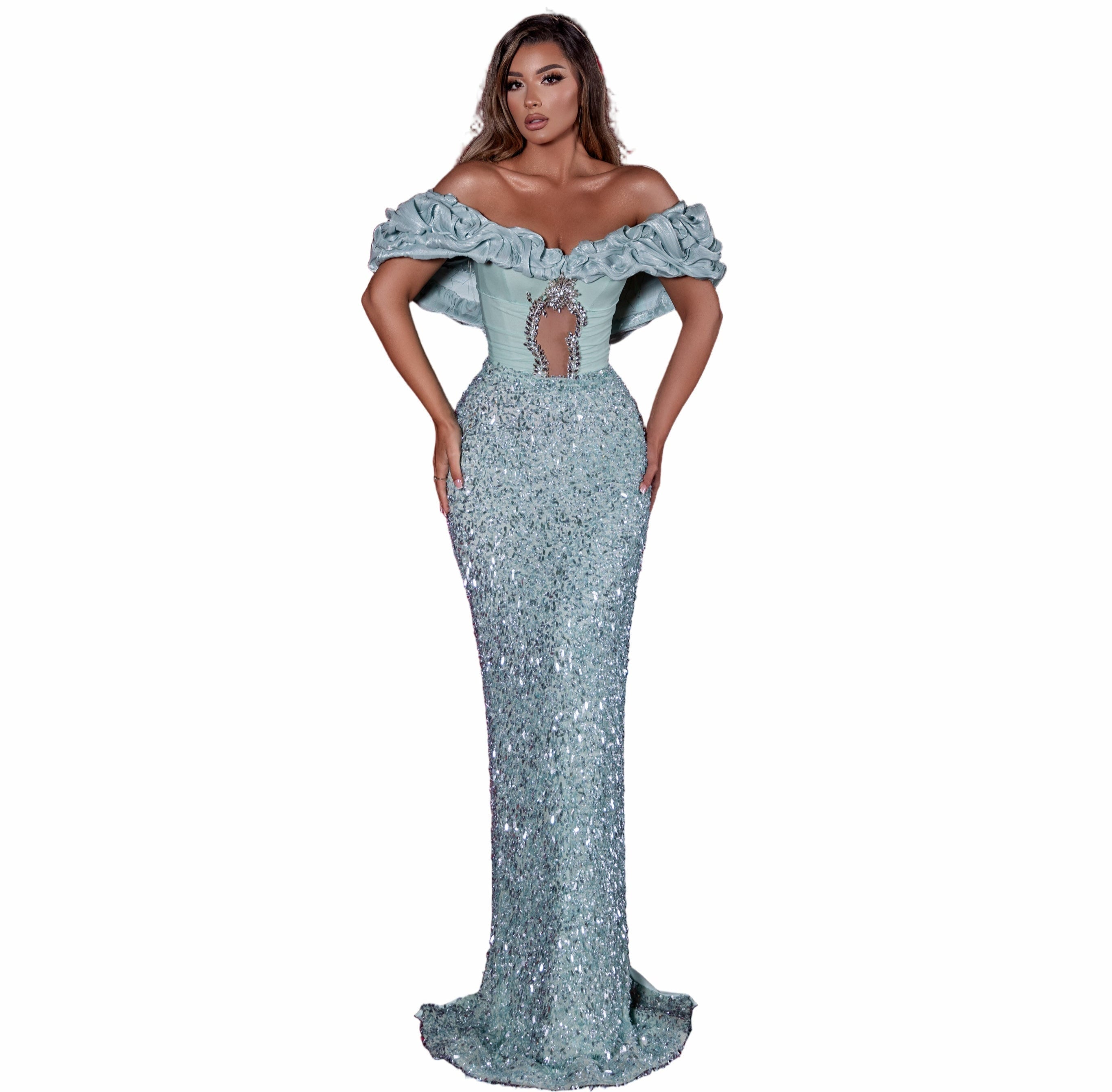 Woman in a silver off-shoulder gown standing in an empty theater with red seats.